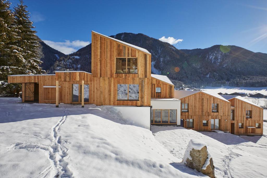 ein Zuhause im Schnee mit Bergen im Hintergrund in der Unterkunft Bio Natur Refugium Blaslahof **** in Gsieser Tal