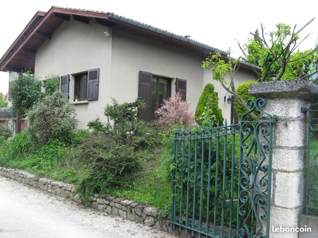 a white house with a gate in front of it at Le Raïs in Noyarey