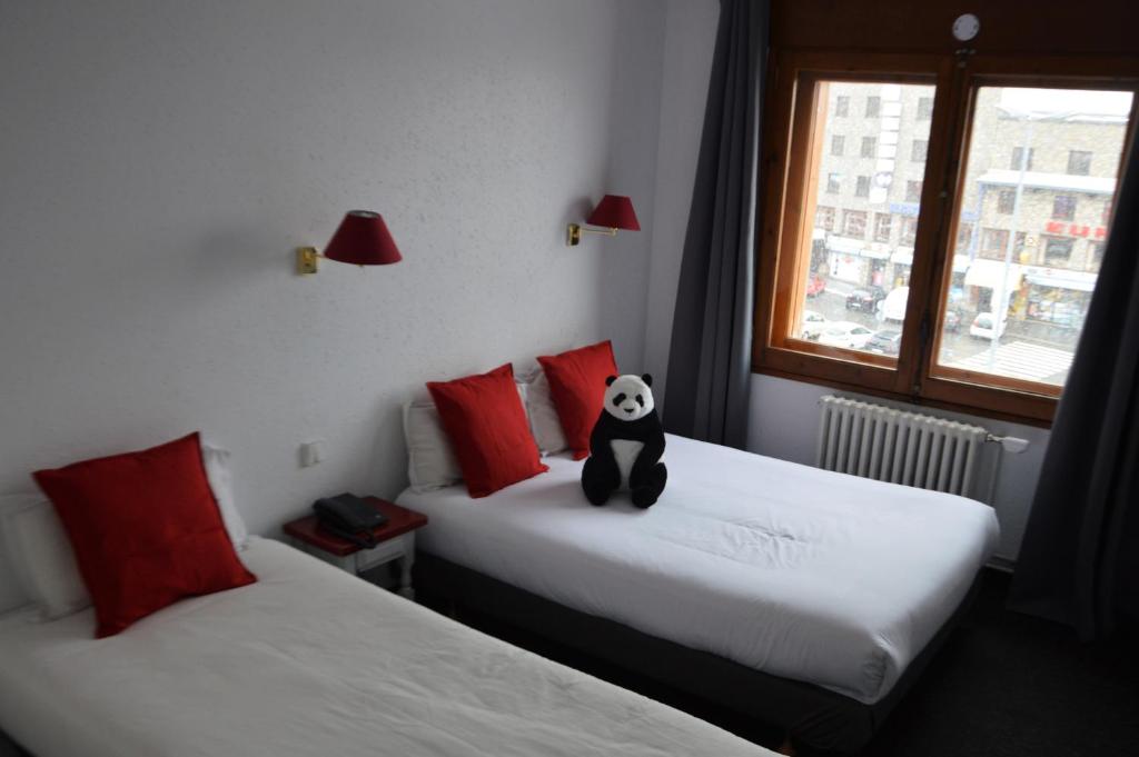 En eller flere senger på et rom på Hotel Panda