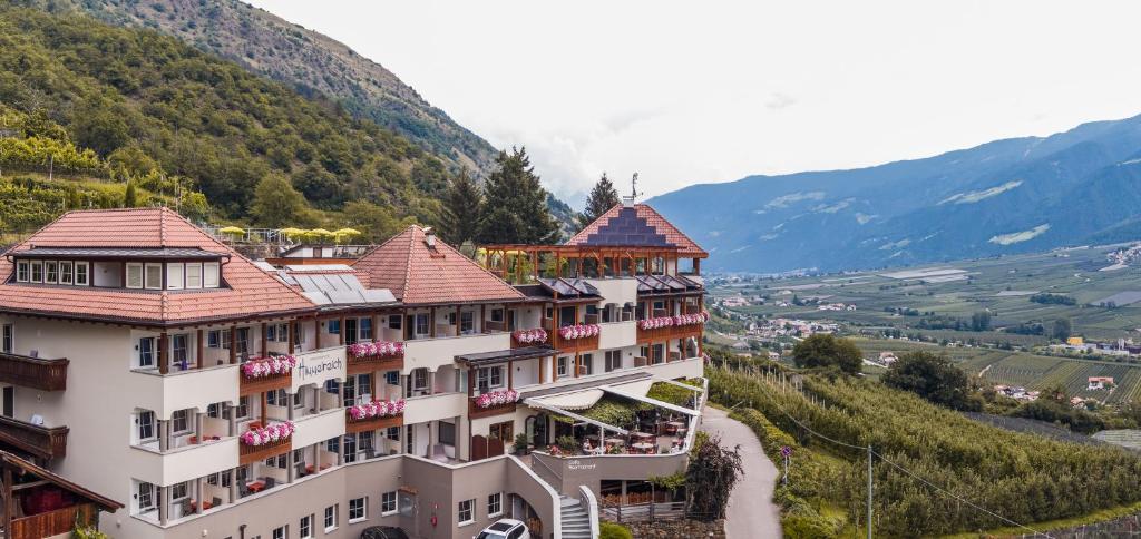 a hotel on a hill with mountains in the background at Panorama Hotel Himmelreich in Castelbello-ciardes