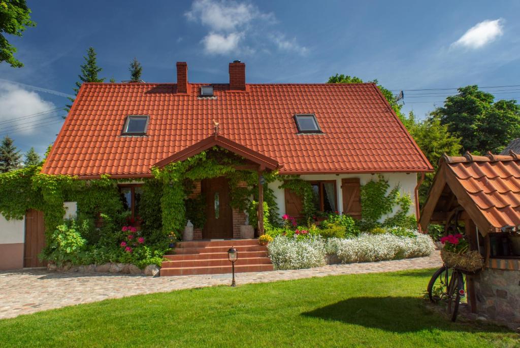 ein Haus mit orangefarbenem Kacheldach in der Unterkunft Nad Rumianem in Rybno