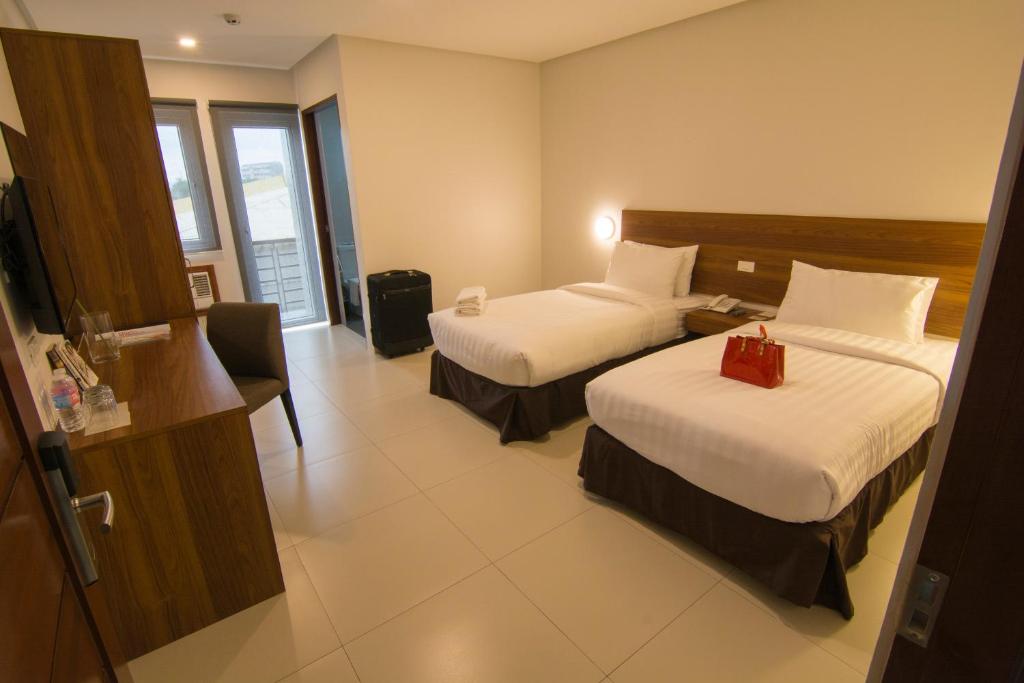 Postel nebo postele na pokoji v ubytování Mango Suites Cauayan