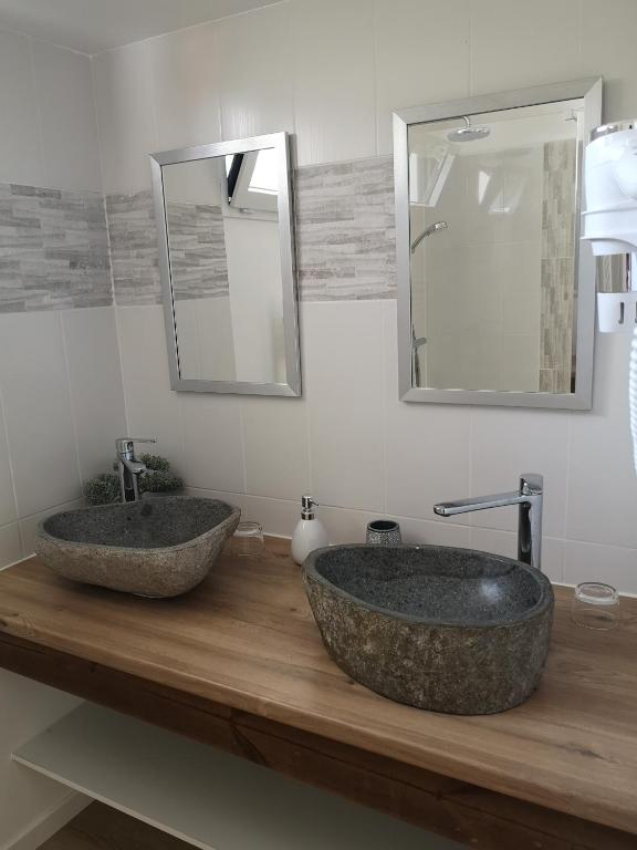 deux lavabos sur un comptoir en bois dans une salle de bain dans l'établissement LES CHAMBRES DU HOURON, à Moliets-et-Maa