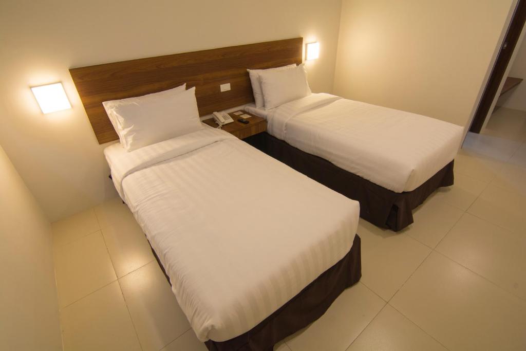 Postel nebo postele na pokoji v ubytování Mango Suites Cauayan