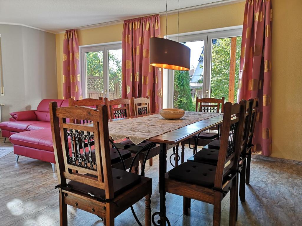 弗賴塔爾的住宿－Ferienhaus an der Wiederitz，一间带木桌和椅子的用餐室