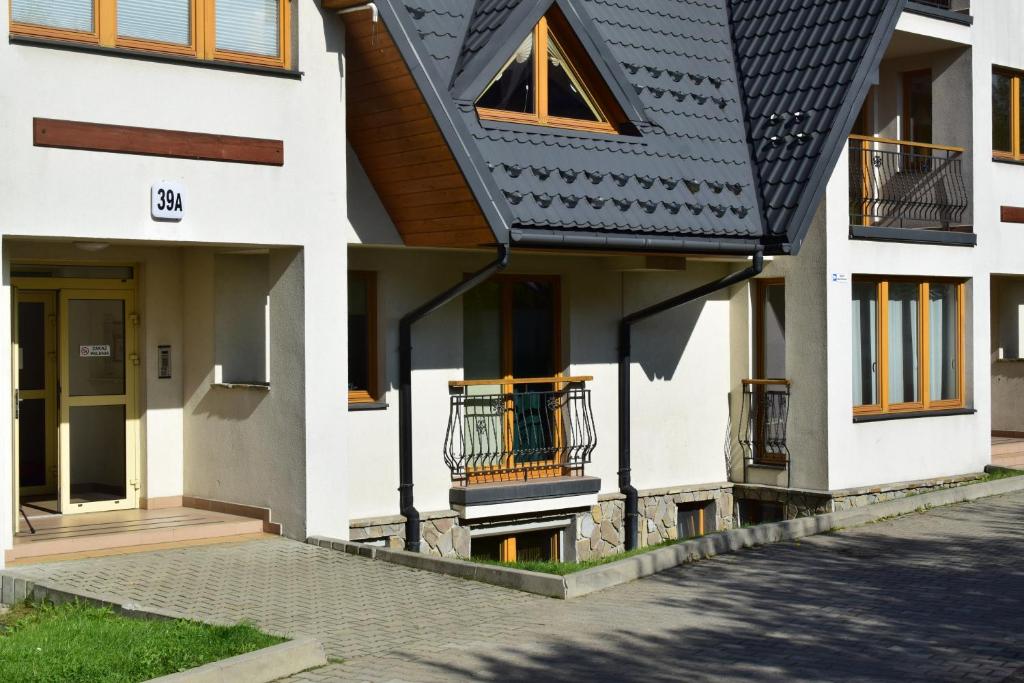 a house with a black and white roof at Apartament DobraNocka in Poronin