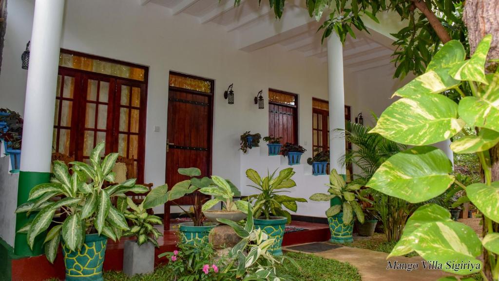 una casa con plantas delante de ella en Mango Villa Sigiriya, en Sigiriya