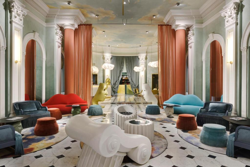 a lobby with colorful chairs and tables in a building at Leon's Place Hotel In Rome in Rome