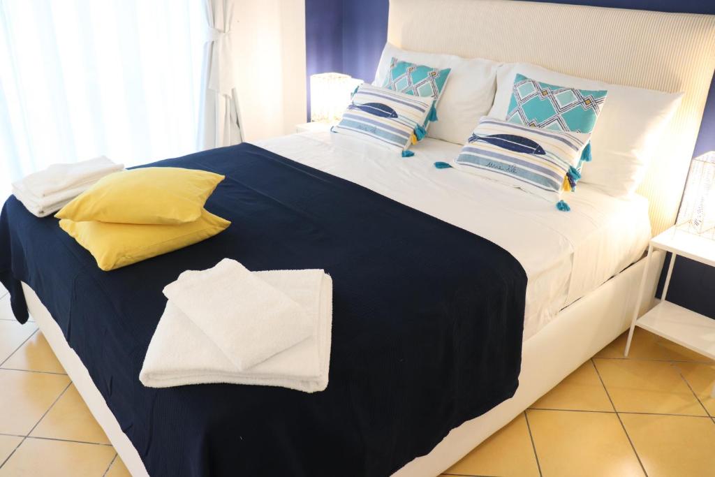 ein großes Bett mit einer blauen Decke und Kissen in der Unterkunft Lemon Suite in Neapel