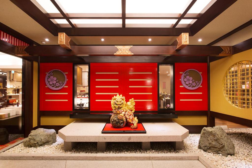 um quarto com paredes vermelhas e uma mesa e algumas pedras em Yamanaka Onsen Kissho Yamanaka em Kaga