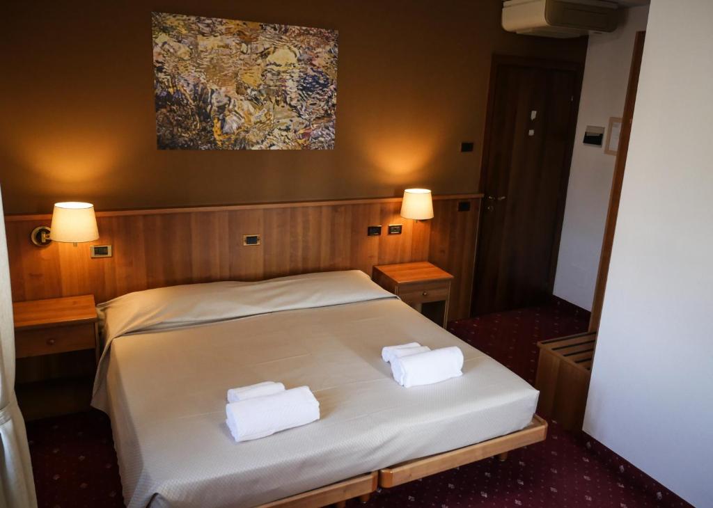1 dormitorio con 1 cama y 2 toallas blancas en VILLANOVA HOTEL, en San Bonifacio