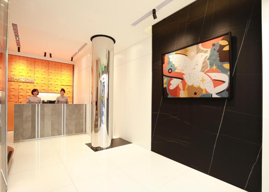 a lobby of a restaurant with a painting on the wall at Cityinn Hotel Taipei Station Branch I in Taipei