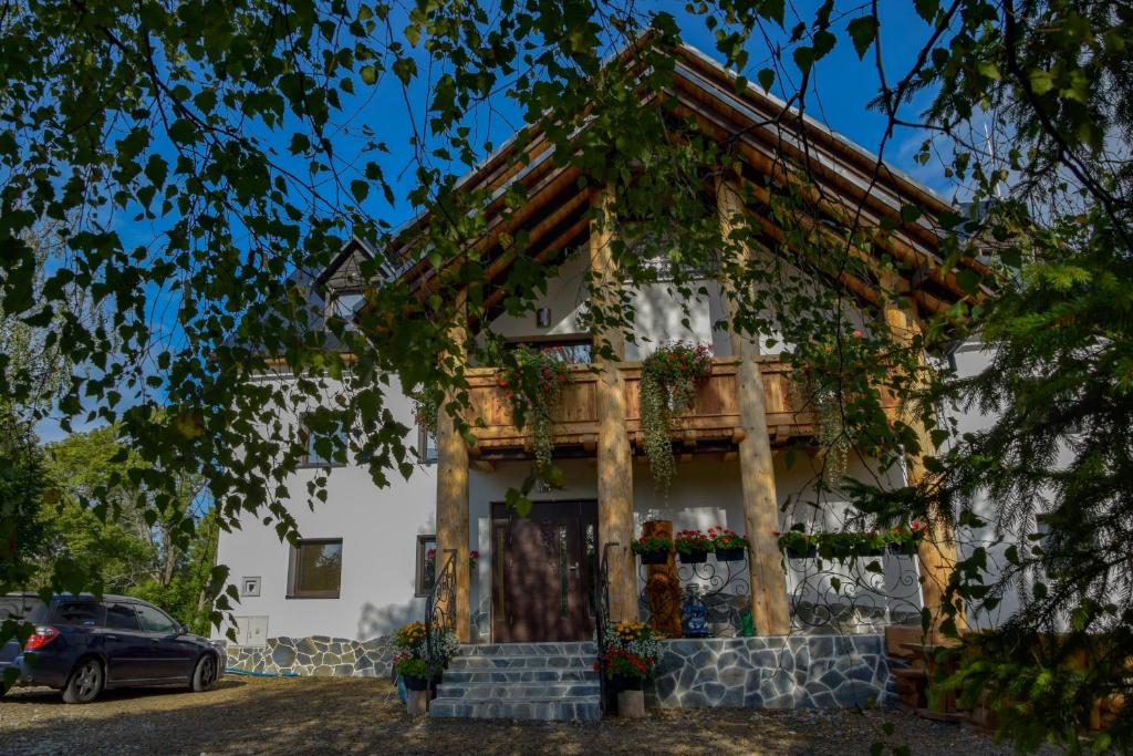 een huis met een veranda en een auto voor de deur bij Bieszczadzka Kraina in Ustrzyki Dolne