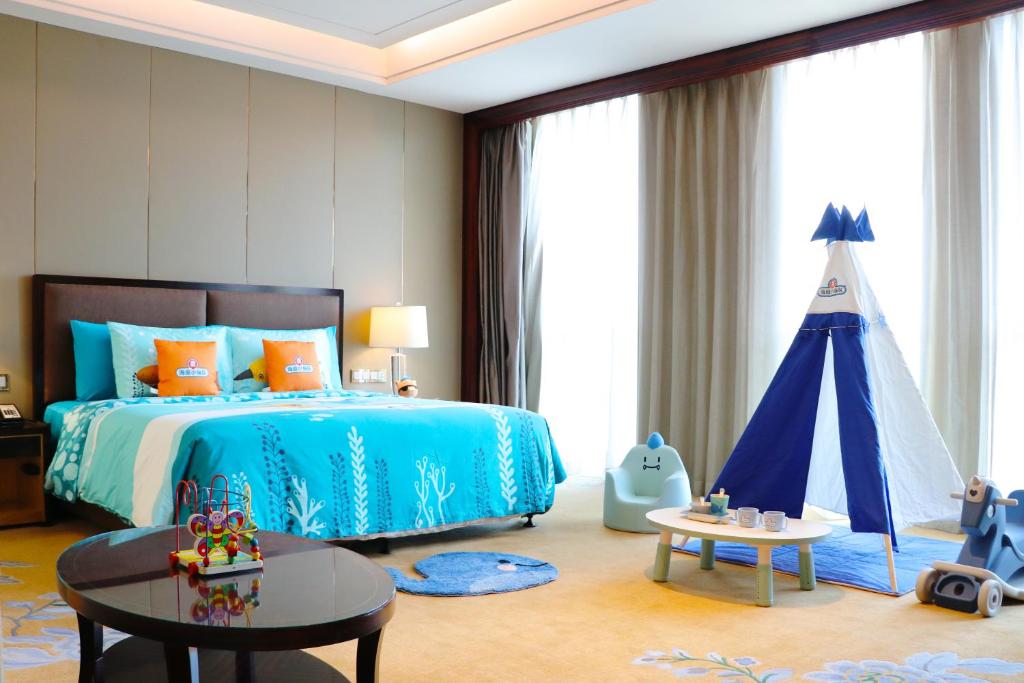a bedroom with a blue bed and a tent at Wanda Vista Taiyuan in Taiyuan