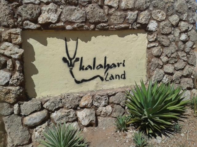 a sign on the side of a stone wall at Aranos Kalahariland Guest Farm in Aranos