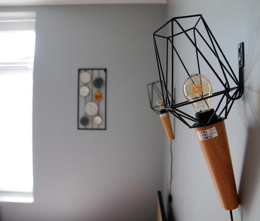 eine Lampe mit einem Baseballschläger an der Wand in der Unterkunft T2 de charme N3 Valenciennes Netflix, Wifi, in Aulnoy