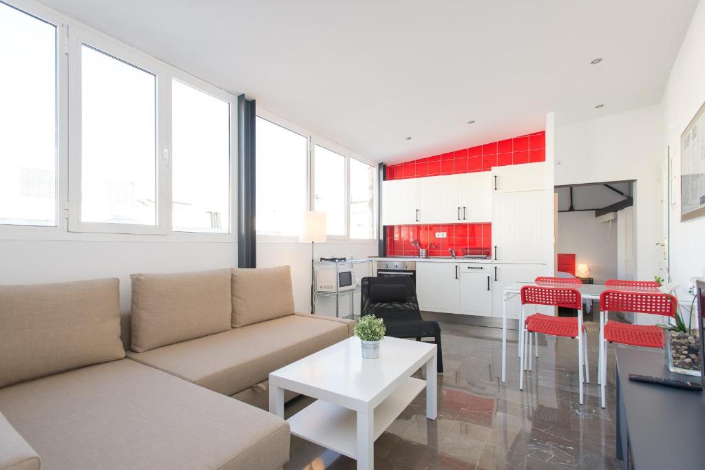 a living room filled with furniture and a large window at Apartamentos Calle Rosario in Seville