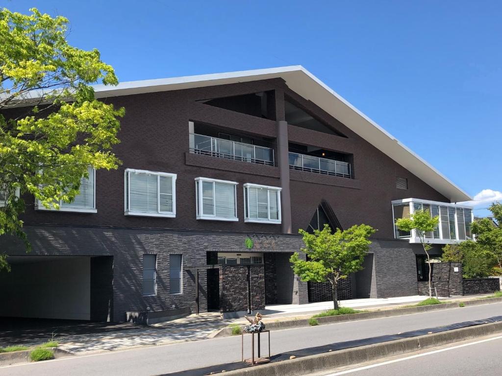 a brown building with white windows on a street at Hotel Grand Vert Kyu Karuizawa in Karuizawa