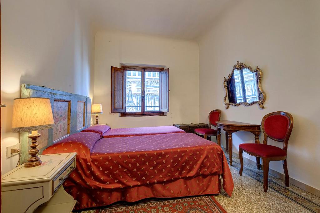 - une chambre avec un lit, une table et des chaises dans l'établissement Eden, à Florence