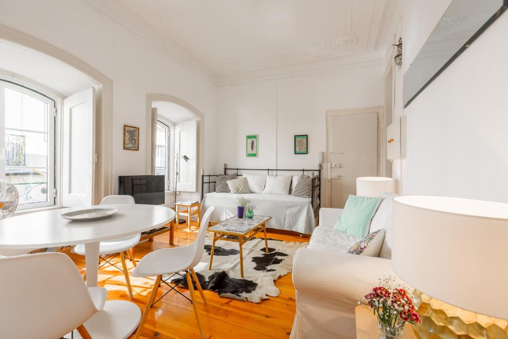 een woonkamer met witte meubels en een tafel bij Spacious, Bright and Sunny Apartment, By TimeCooler in Lissabon