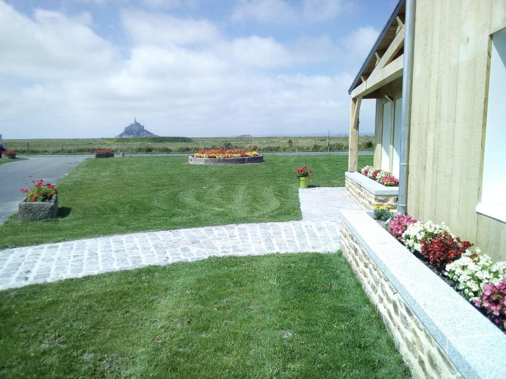 uma vista de uma casa com um quintal com flores em Etoile des Grèves em Ardevon