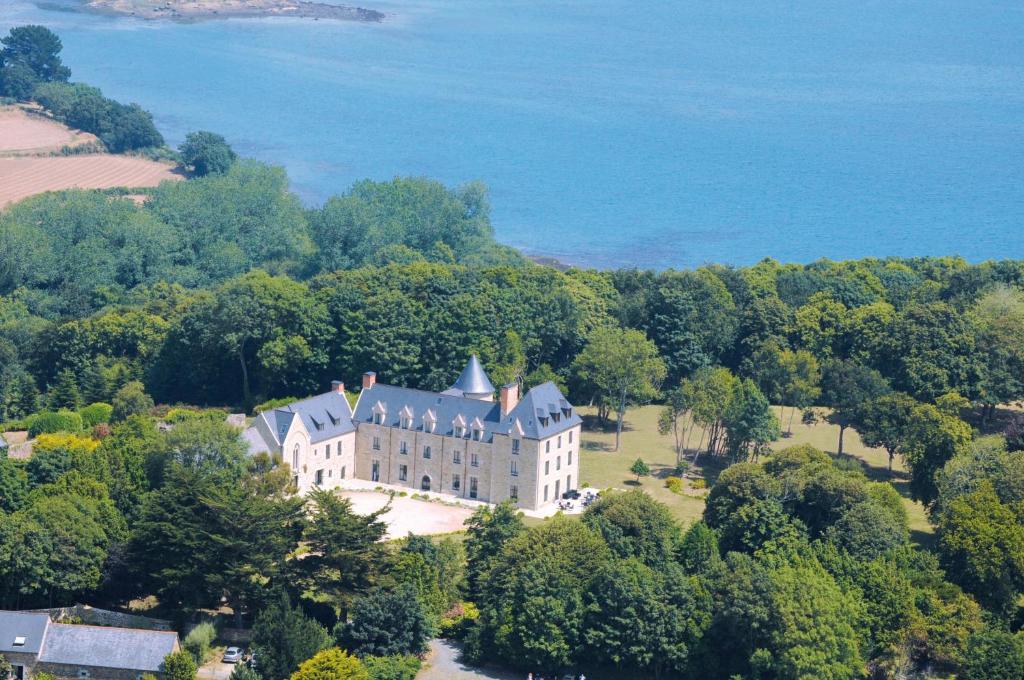 - une vue aérienne sur un château dans les arbres dans l'établissement Manoir de Kergrec'h, à Plougrescant