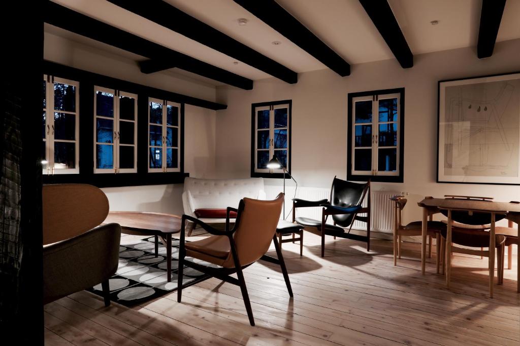 a room with chairs and tables and windows at House of Finn Juhl Hakuba in Hakuba