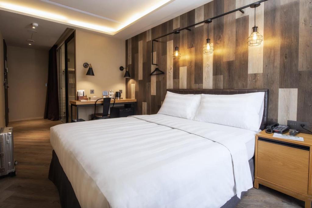 a bedroom with a large white bed and a desk at City Suites - Beimen in Taipei