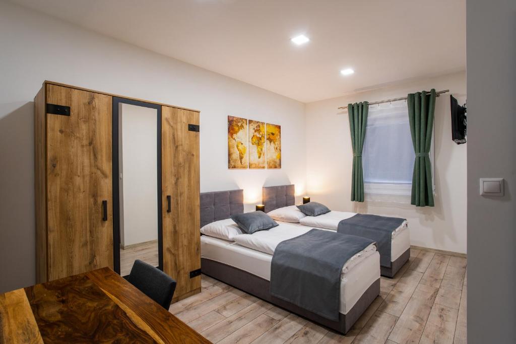 a bedroom with two beds and a table at Penzión Imperial in Žarnovica