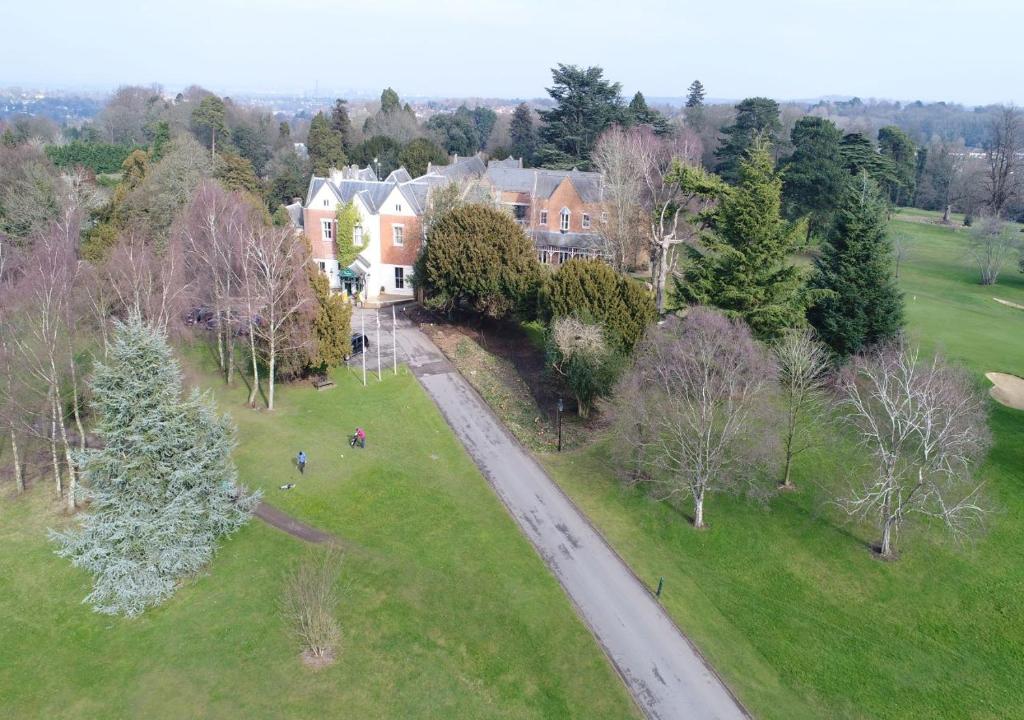 uma vista aérea de uma casa com árvores e uma estrada em Coulsdon Manor Hotel and Golf Club em Croydon