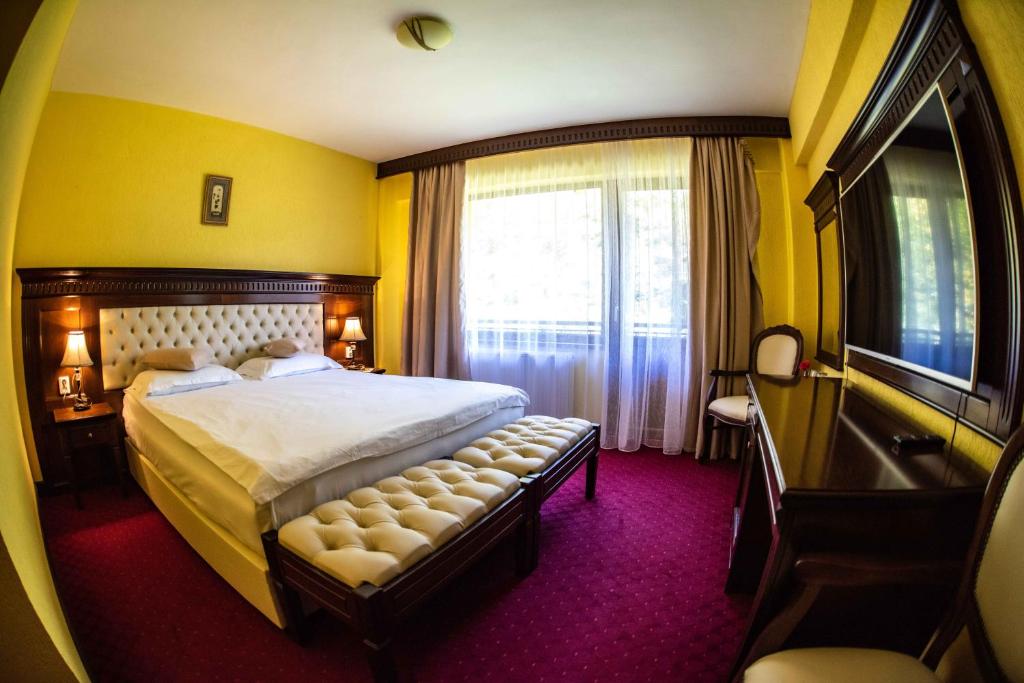 バイレ・オラネシュティにあるHotel Trei Braziの大きなベッドと窓が備わるホテルルームです。