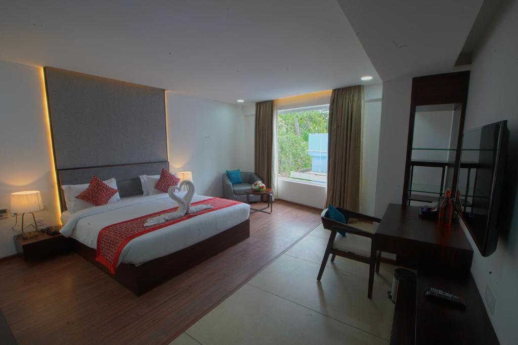 a bedroom with a bed and a desk and a piano at The Terrace by Ladder Mgd by Citrine in Trivandrum