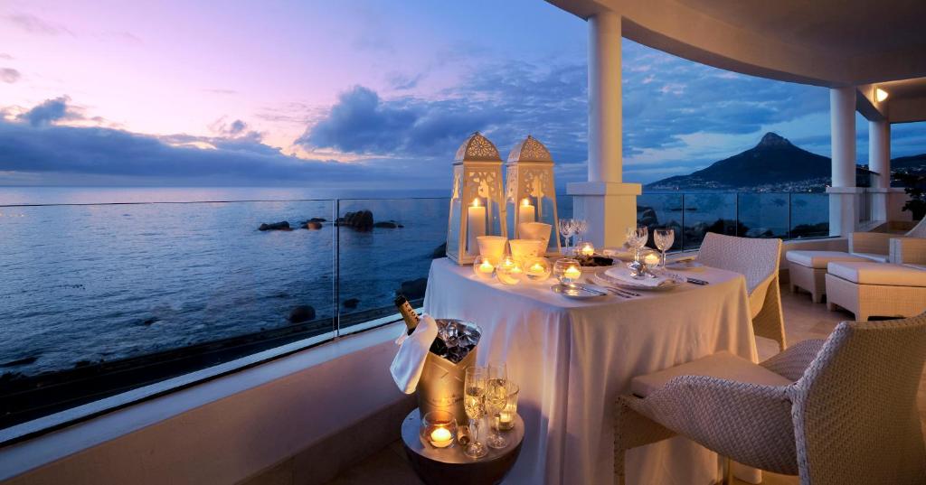 a dining room with a table and a view of the ocean at Twelve Apostles Hotel & Spa in Cape Town