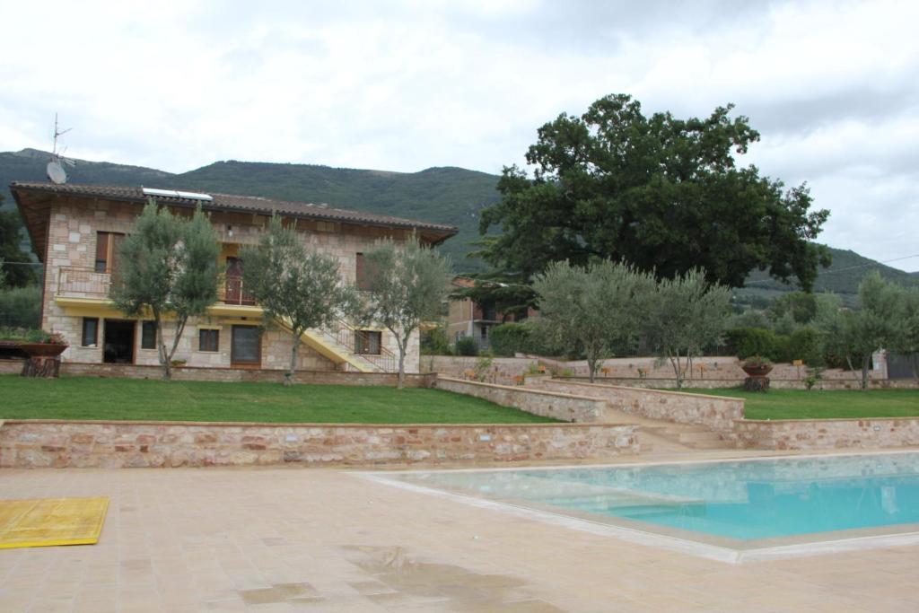 an external view of a house and a swimming pool at Le querce di mamre in Passaggio Di Assisi