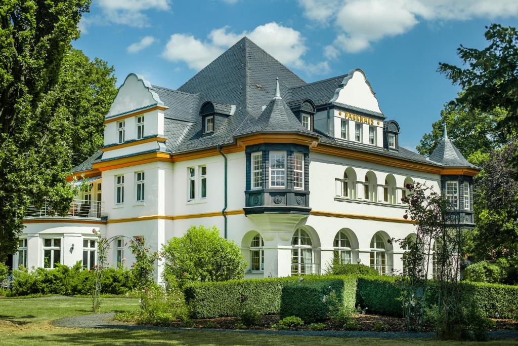 een groot wit huis met een grijs dak bij Villa Parkhaus in Wernigerode