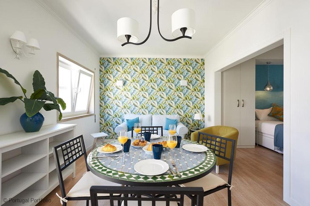 a dining room with a table with glasses of orange juice at Rainha II Beach Apartment in Cascais