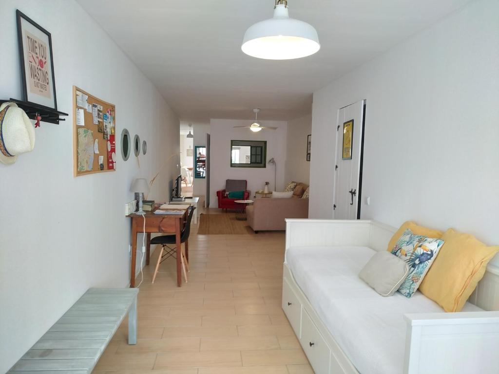 a living room with a white couch and a table at Casa Amarela in Tavira