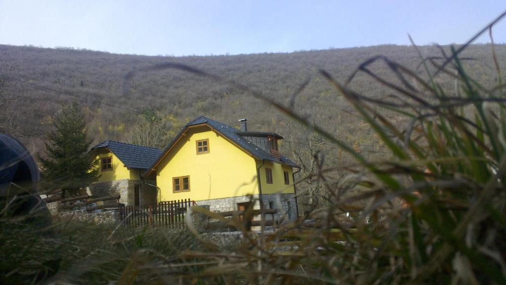 une maison jaune assise au sommet d'une colline dans l'établissement Guest House - Stari Javor B&B, à Prozor
