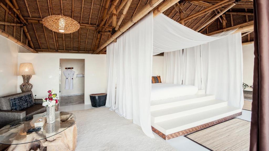 ein Schlafzimmer mit einem Bett und ein Wohnzimmer in der Unterkunft La Crique Nature & Spa in Ad-Dakhla
