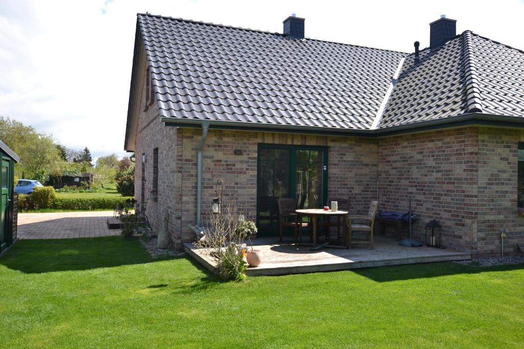 a brick house with a table in a yard at Dat Dardel Hus in Born