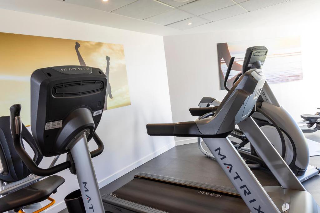 a gym with two treadmills and a treadmill at Thalazur Port-Camargue - Hotel & Spa in Le Grau-du-Roi