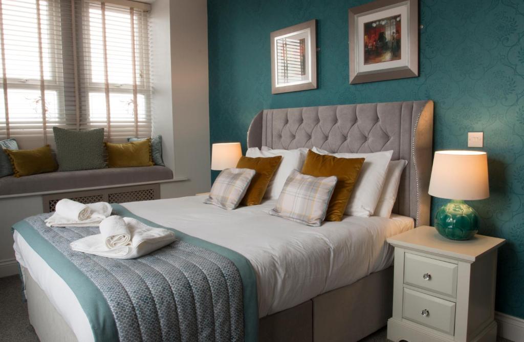 a bedroom with a large bed with towels on it at The Portland in Ashington