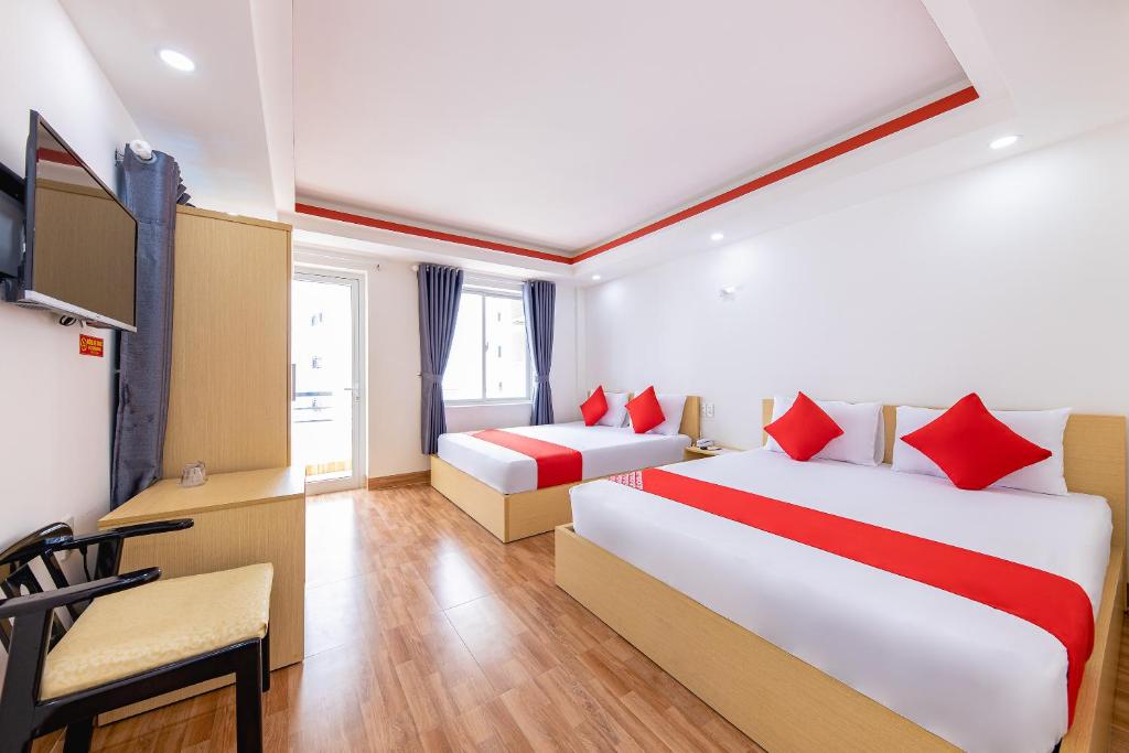 Habitación de hotel con 2 camas y mesa en M&C Hotel Nha Trang en Nha Trang