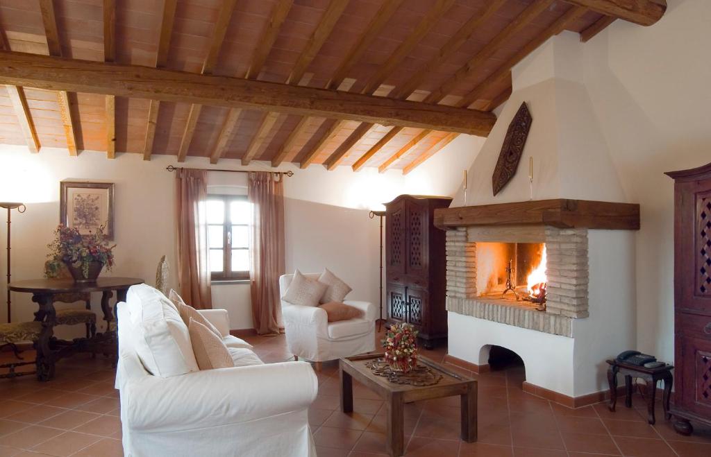 uma sala de estar com mobiliário branco e uma lareira em Le Torri em Barberino di Val dʼElsa