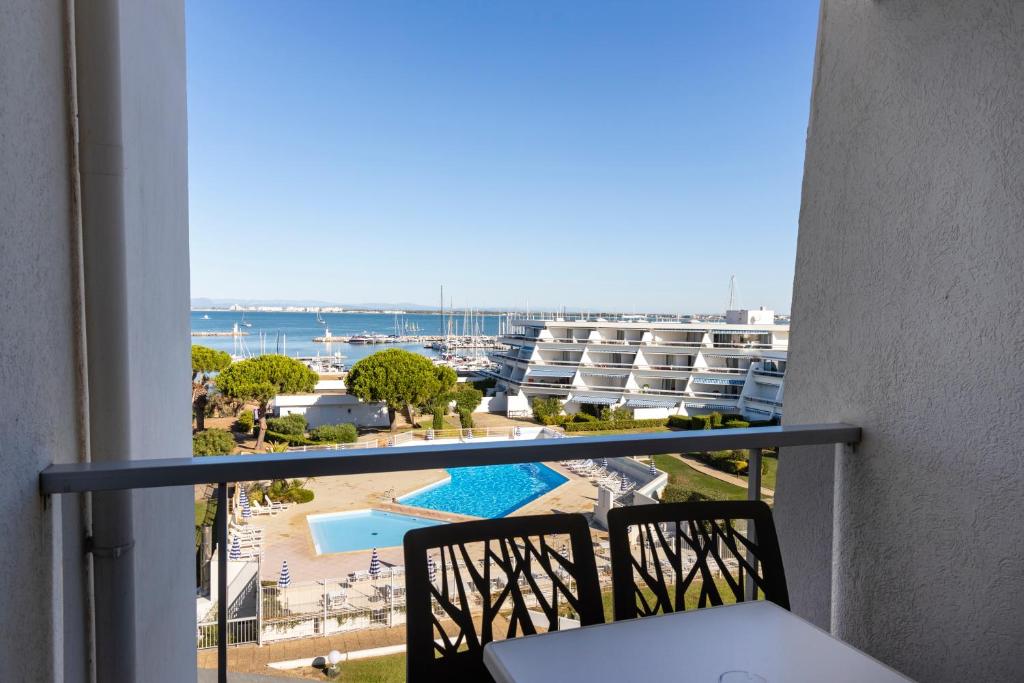 
a view from a balcony of a building with a view of the ocean at Hotel & Spa Les Bains de Camargue by Thalazur in Le Grau-du-Roi
