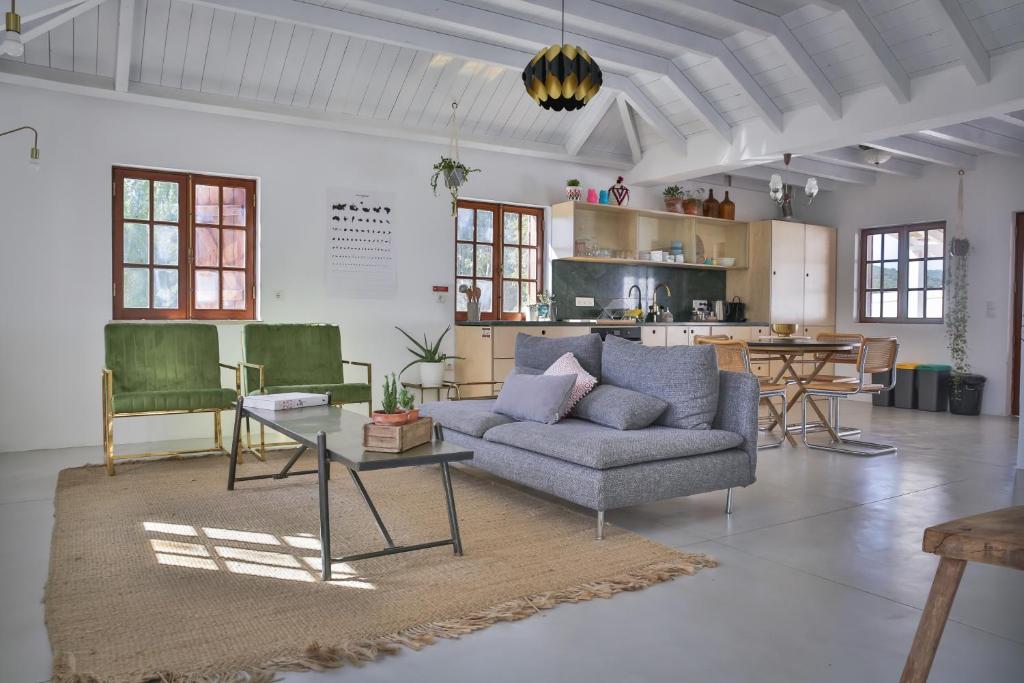 a living room with a couch and chairs and a table at Monte dos tres pocos in Cercal