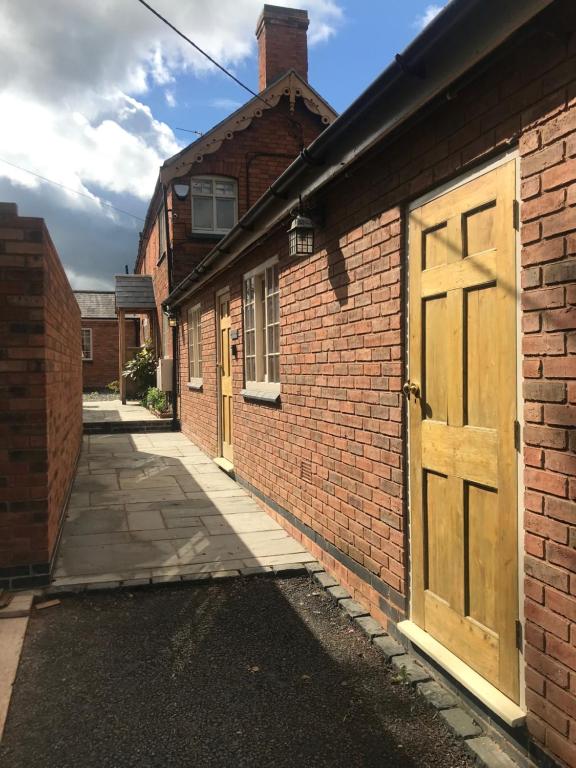 un edificio de ladrillo con una puerta de madera. en The Forge Guest Rooms, en Long Whatton