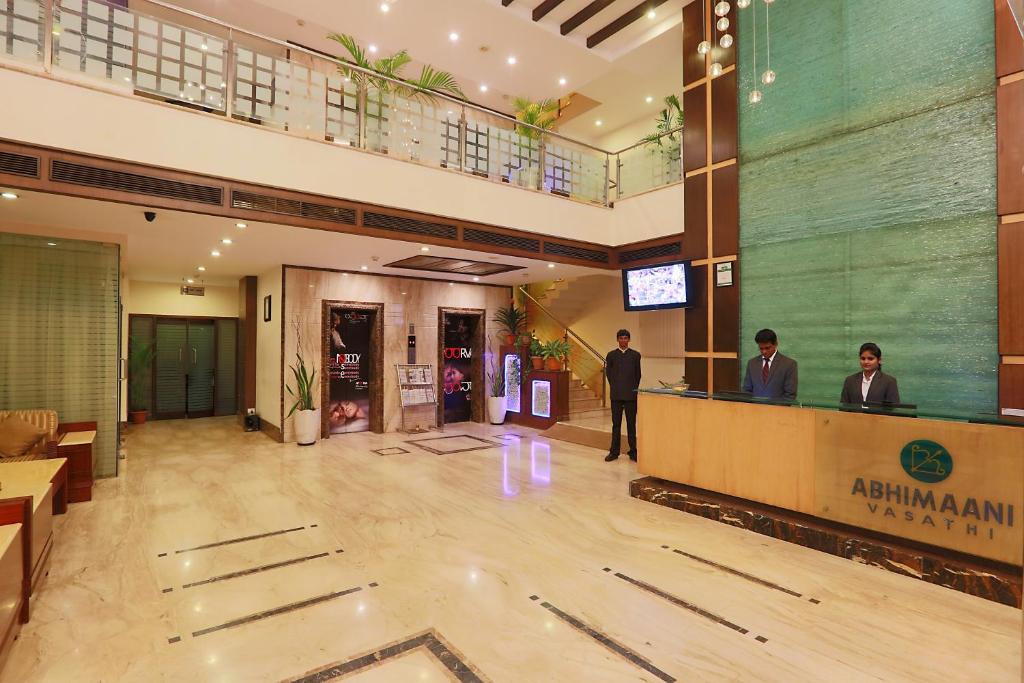 a man standing in the lobby of a building at Hotel Abhimaani Vasathi, Rajajinagar in Bengaluru