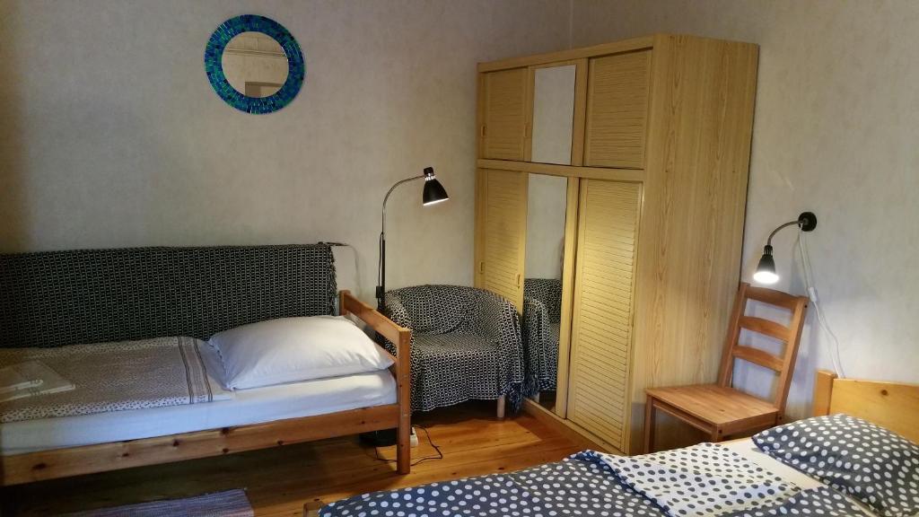 1 dormitorio con cama, silla y espejo en Derű Vendégház és Lovasudvar en Fenyőfő