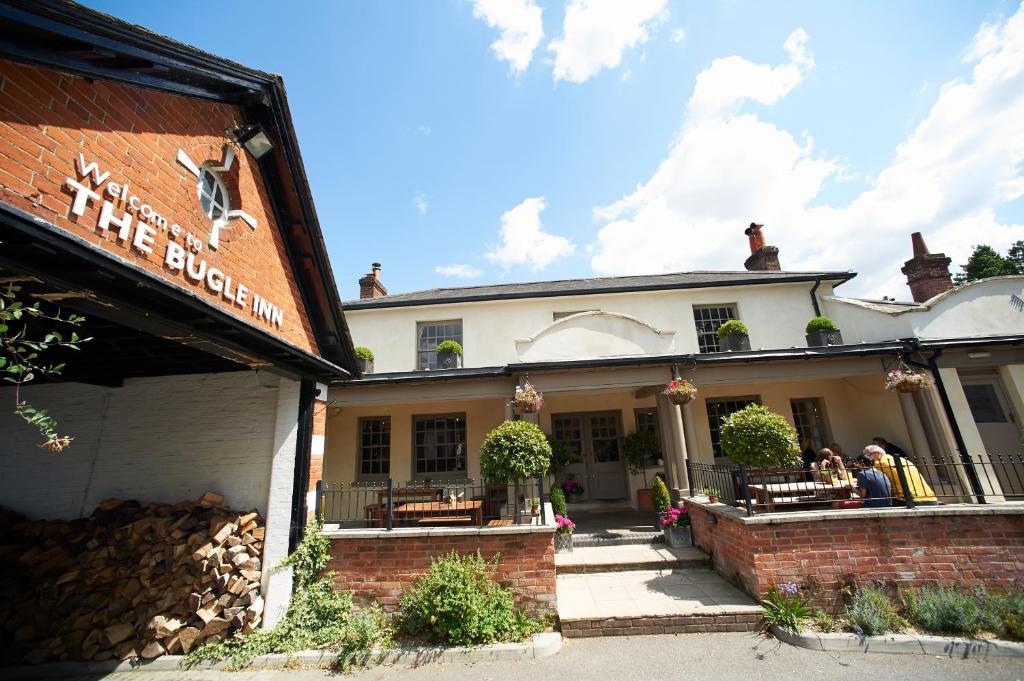 a building with people sitting at tables in front of it at The Bugle Inn Twyford in Winchester